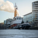 A tug boat is parked in front of a building  screen for extension Chrome web store in OffiDocs Chromium