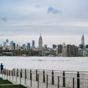 Man standing on embankment of river in big city  screen for extension Chrome web store in OffiDocs Chromium