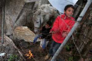 Free download Palestinian children warm up in front of a fire in a hovel during the cold and rainy weather in the Jabalia refugee camp in the northern Gaza Strip on January 1, 2018. free photo or picture to be edited with GIMP online image editor