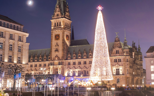 A christmas tree is lit up in front of a building from Chrome web store to be run with OffiDocs Chromium online A christmas tree is lit up in front of a building from Chrome web store to be run with OffiDocs Chromium online