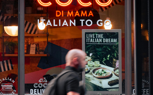 A man walking past a cafe with the words coco di mamma italian to go  from Chrome web store to be run with OffiDocs Chromium online