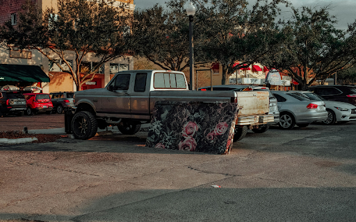 A truck parked in a parking lot with a mattress on the back  from Chrome web store to be run with OffiDocs Chromium online
