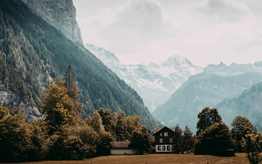 Brown Wooden House Near Tall Trees and Mountains  from Chrome web store to be run with OffiDocs Chromium online