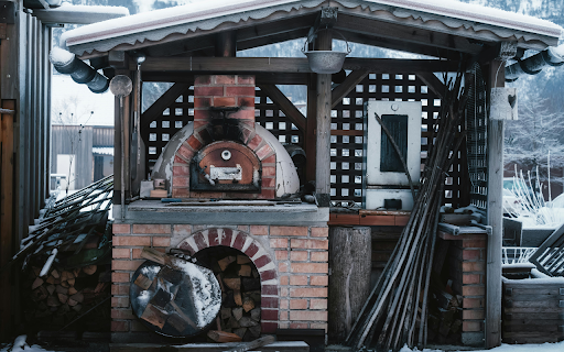 Cozy Outdoor Pizza Oven in Snowy Setting  from Chrome web store to be run with OffiDocs Chromium online