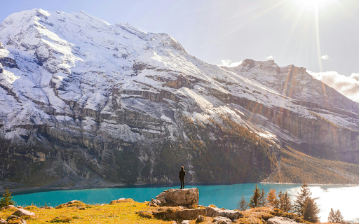 Hiker on a Rock Above a Mountain Lake in the Swiss Alps  from Chrome web store to be run with OffiDocs Chromium online