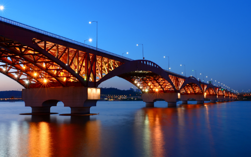 Illuminated Bridge Spanning a Tranquil River at Dusk  from Chrome web store to be run with OffiDocs Chromium online
