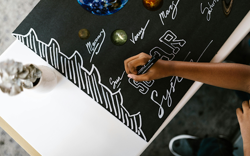 Person Writing on a Poster Using Black Marker  from Chrome web store to be run with OffiDocs Chromium online
