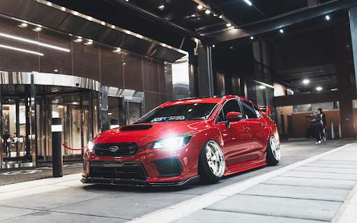 Red Subaru Parked in Front of Building  from Chrome web store to be run with OffiDocs Chromium online