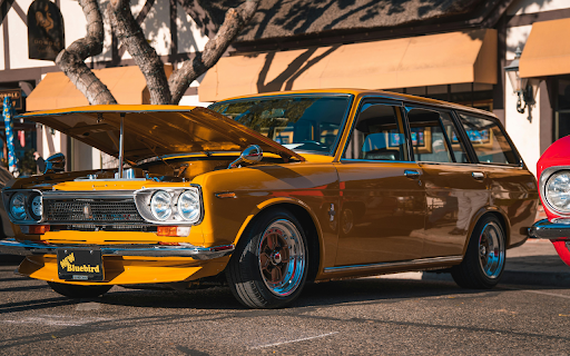 Shiny Yellow Station Wagon Parked Beside a Tree  from Chrome web store to be run with OffiDocs Chromium online