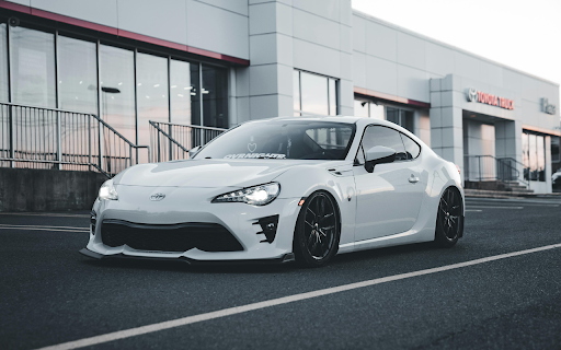 Sleek White Sports Car at Toyota Dealership  from Chrome web store to be run with OffiDocs Chromium online