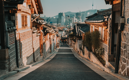 Traditional Village Lane Leading to Modern Skyline  from Chrome web store to be run with OffiDocs Chromium online