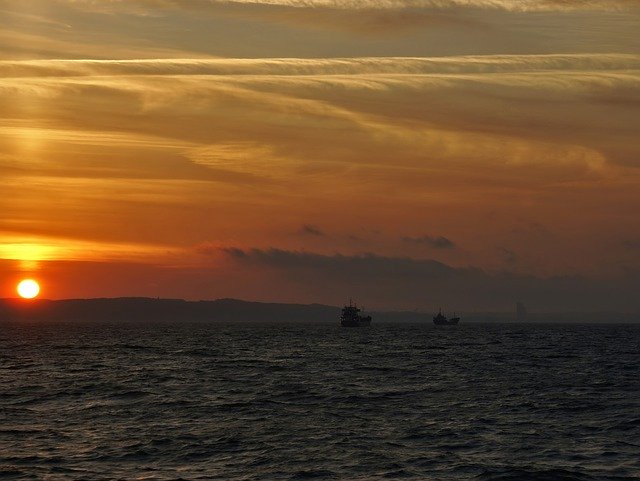 日没の海のXNUMXつの船を無料でダウンロード-GIMPオンラインイメージエディターで編集できる無料の写真または画像