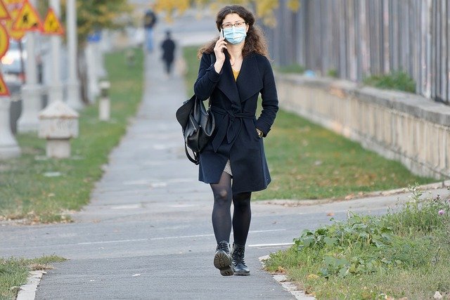 Baixe gratuitamente uma imagem gratuita de máscara facial de mulher andando por telefone para ser editada com o editor de imagens on-line gratuito do GIMP