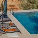 A pool with lounge chairs and umbrellas  screen for extension Chrome web store in OffiDocs Chromium