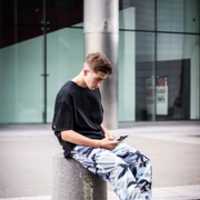 Kostenloser Download Männlicher Teenager, der mit Telefon sitzt, kostenloses Foto oder Bild, das mit GIMP Online-Bildbearbeitung bearbeitet werden kann