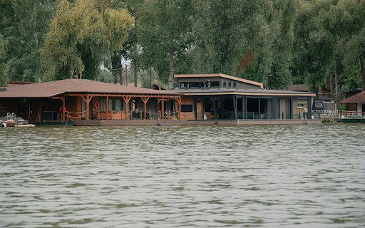 A house on the water with a dock and a tree  from Chrome web store to be run with OffiDocs Chromium online