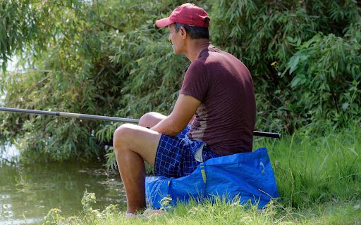 Man sitting in bushes fishing  from Chrome web store to be run with OffiDocs Chromium online