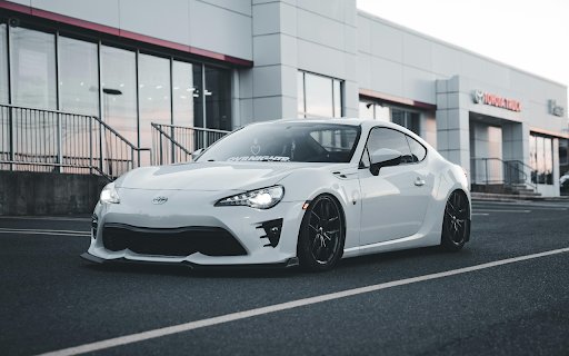 Sleek White Sports Car at Toyota Dealership  from Chrome web store to be run with OffiDocs Chromium online