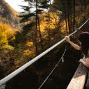 Woman gazing from bridge amidst autumn forest  screen for extension Chrome web store in OffiDocs Chromium