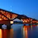 Illuminated Bridge Spanning a Tranquil River at Dusk  screen for extension Chrome web store in OffiDocs Chromium