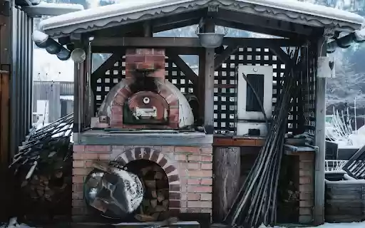 Cozy Outdoor Pizza Oven in Snowy Setting  from Chrome web store to be run with OffiDocs Chromium online