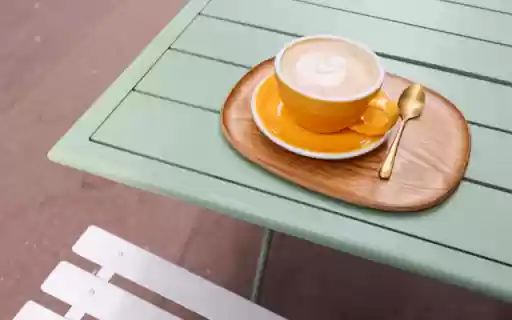 Elegance in Every Sip: Cappuccino on a Green Table  from Chrome web store to be run with OffiDocs Chromium online