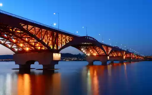 Illuminated Bridge Spanning a Tranquil River at Dusk  from Chrome web store to be run with OffiDocs Chromium online