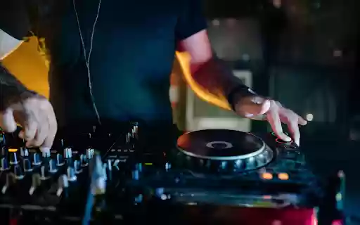 Man in Blue Crew Neck T shirt Playing Dj Controller  from Chrome web store to be run with OffiDocs Chromium online