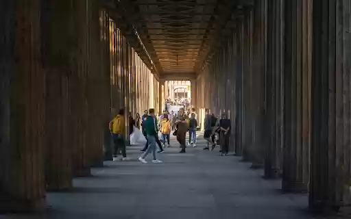 People walking through a long hallway with columns  from Chrome web store to be run with OffiDocs Chromium online