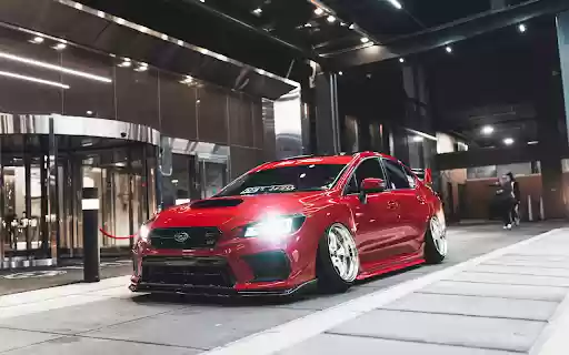 Red Subaru Parked in Front of Building  from Chrome web store to be run with OffiDocs Chromium online